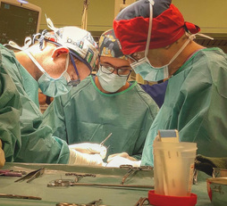 Da sinistra, nella foto ripresa anche come immagine di testa, i chirurghi universitari Piergiorgio Calò, Fabio Medas e Gian Luigi Canu in sala operatoria