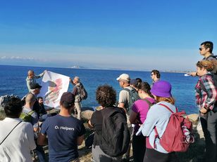 Primo stop. I partecipanti ascoltando la spiegazione del professor Secchi (a sinistra, col cappello nero) sulla geologia della Sardegna, mentre i professori Casini (UniSS, a sinistra) e Naitza (UniCa, a destra) reggono la carta geologica