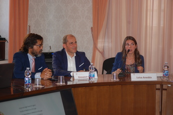 Luisa Anedda espone il contenuto della tesi nel corso della cerimonia in Rettorato. A sinistra Giovanni Marini, avvocato e funzionario dell'Ateneo, e Giovanni Caocci, docente alla Facoltà di Medicina e chirurgia, componente della commissione esaminatrice