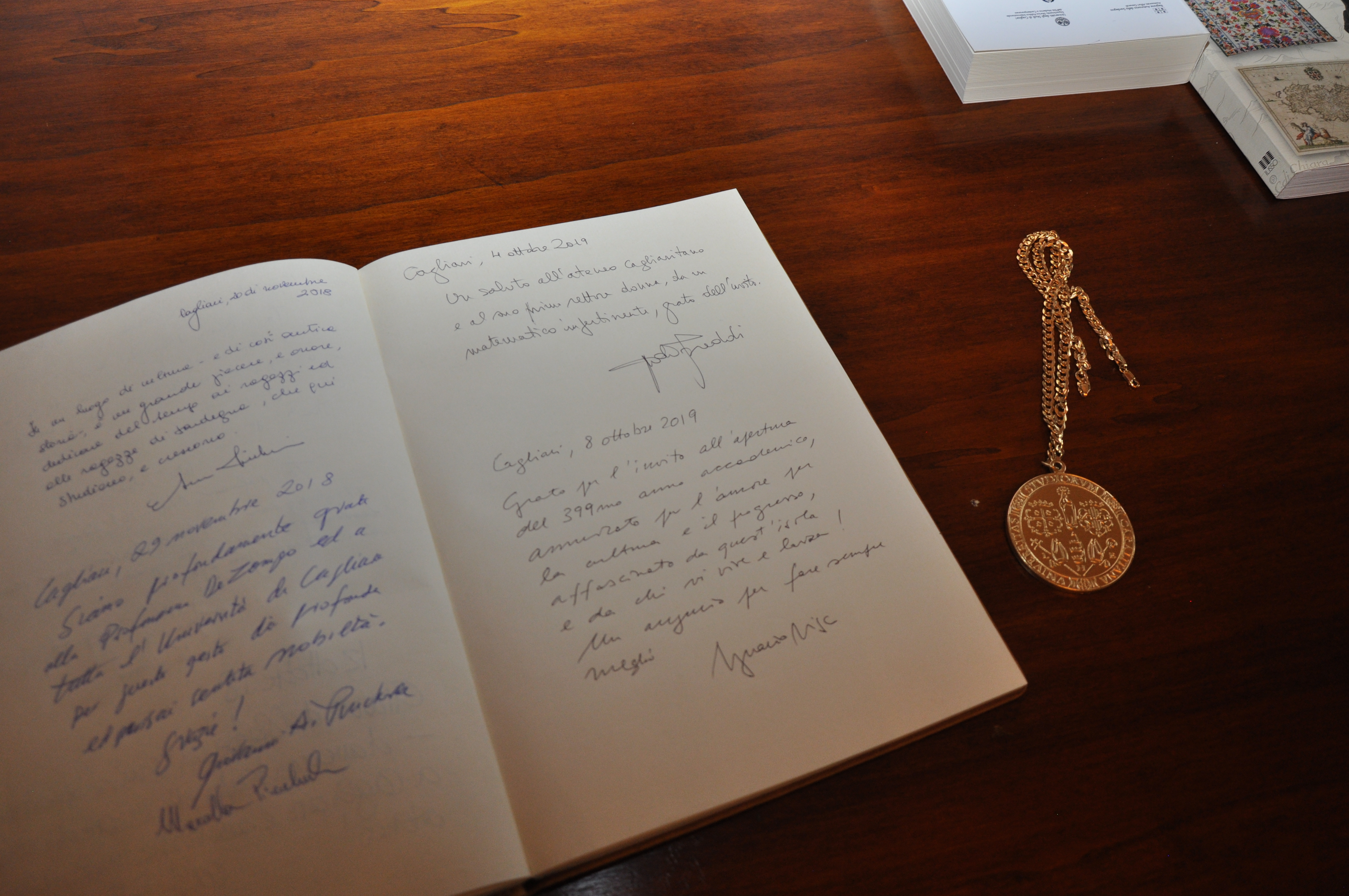 La dedica lasciata sul libro degli ospiti e il medaglione dell'Ateneo