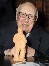 Andrea Camilleri fotografato da Francesco Cogotti davanti ad un'opera della serie "Genti de bidda mia" creata da Pinuccio Sciola