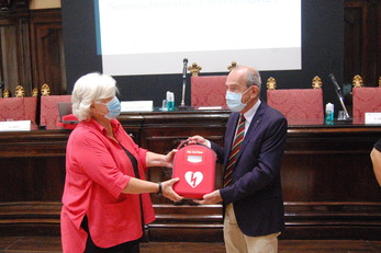 Carlo Carcassi, già docente dell'Ateneo, consegna uno dei defibrillatori