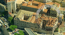 In primo piano, sullo sfondo dell'immagine d'archivio, una veduta aerea del palazzo del rettorato di Cagliari e della vicina Torre dell'elefante