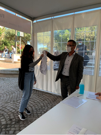 Antonello Mura, presidente della Facolt&agrave; di Studi umanistici, consegna il kit a una studentessa