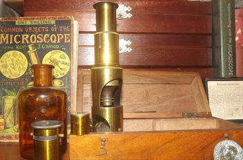 Microscopio d'epoca e libri